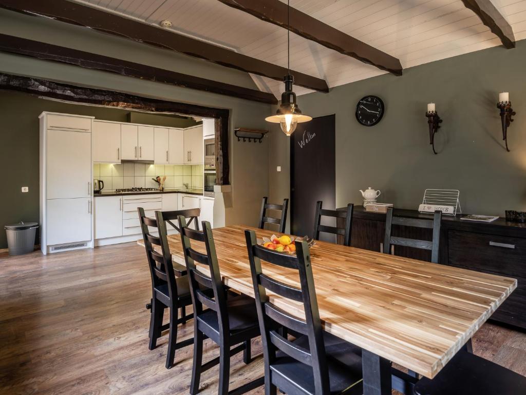 宁斯佩特Koetshuis Nunspeet的厨房以及带木桌和椅子的用餐室。