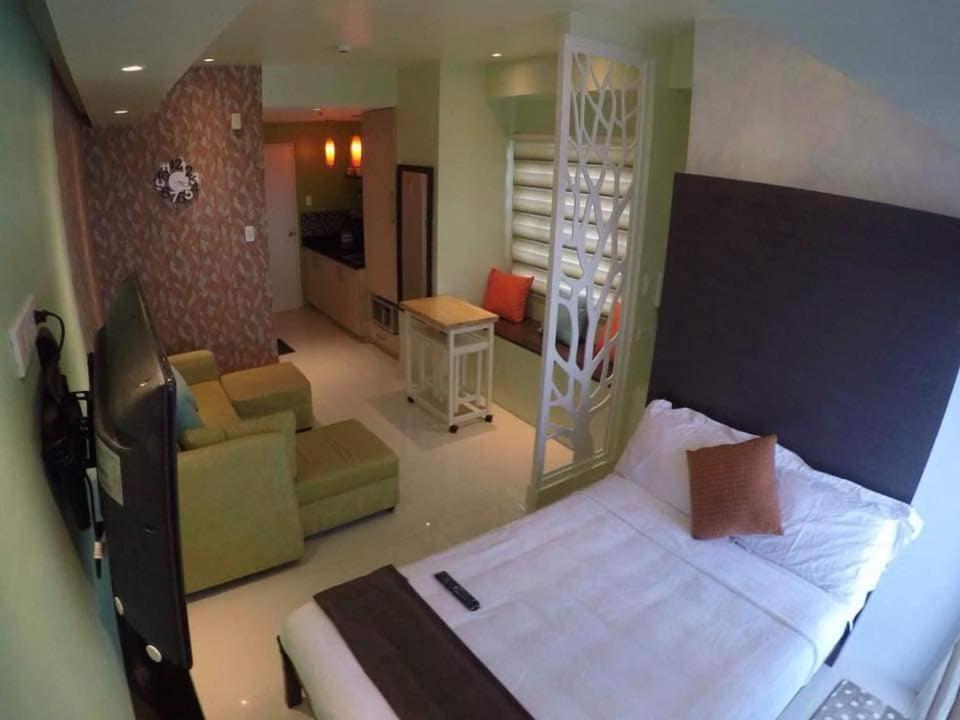大雅台1 Bedroom Unit at SMDC Wind Residences Tagaytay Tower 1 15th floor的一间卧室设有一张床和一间客厅。