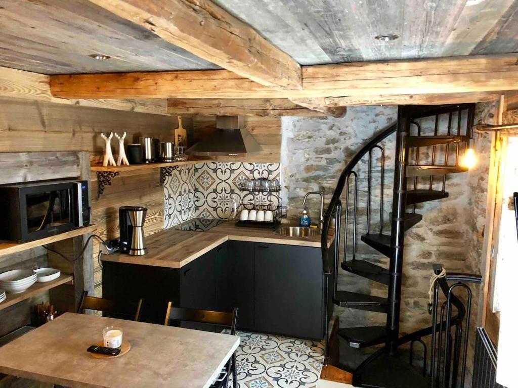 蒂涅le mazot d'urbain的一间厨房,内设桌子和楼梯