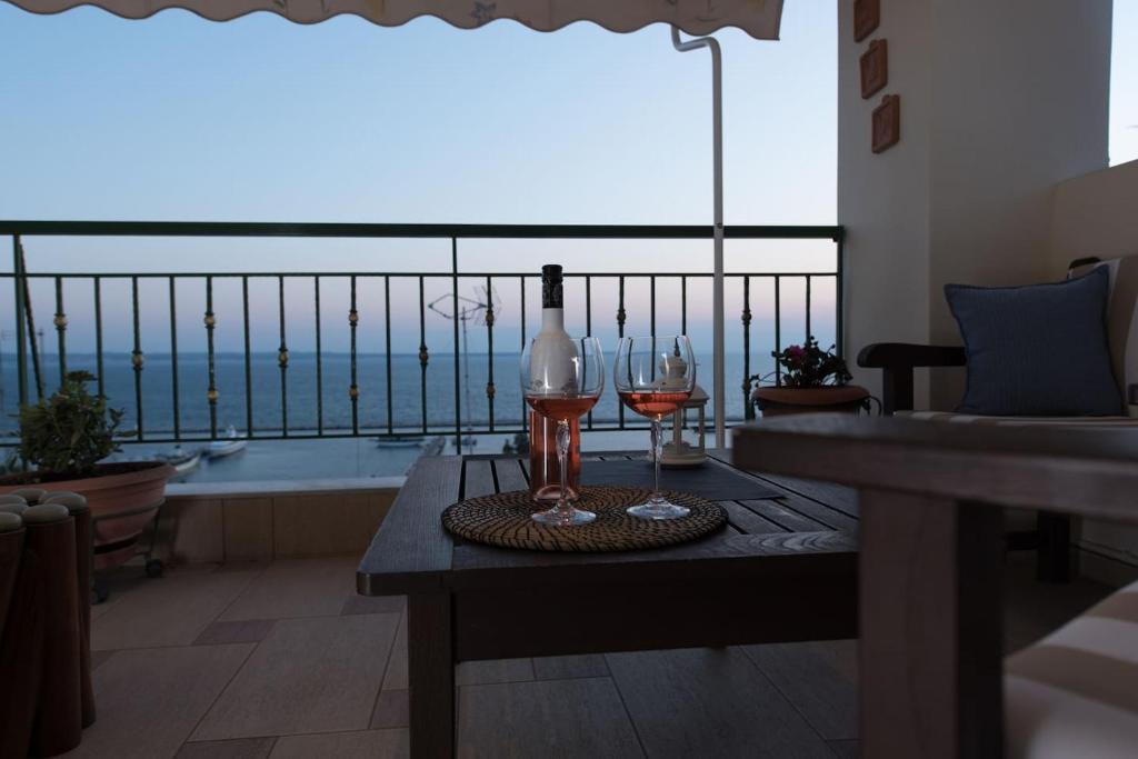 塞萨洛尼基Apartment with marina view的一张桌子,上面放着两杯酒和一瓶葡萄酒