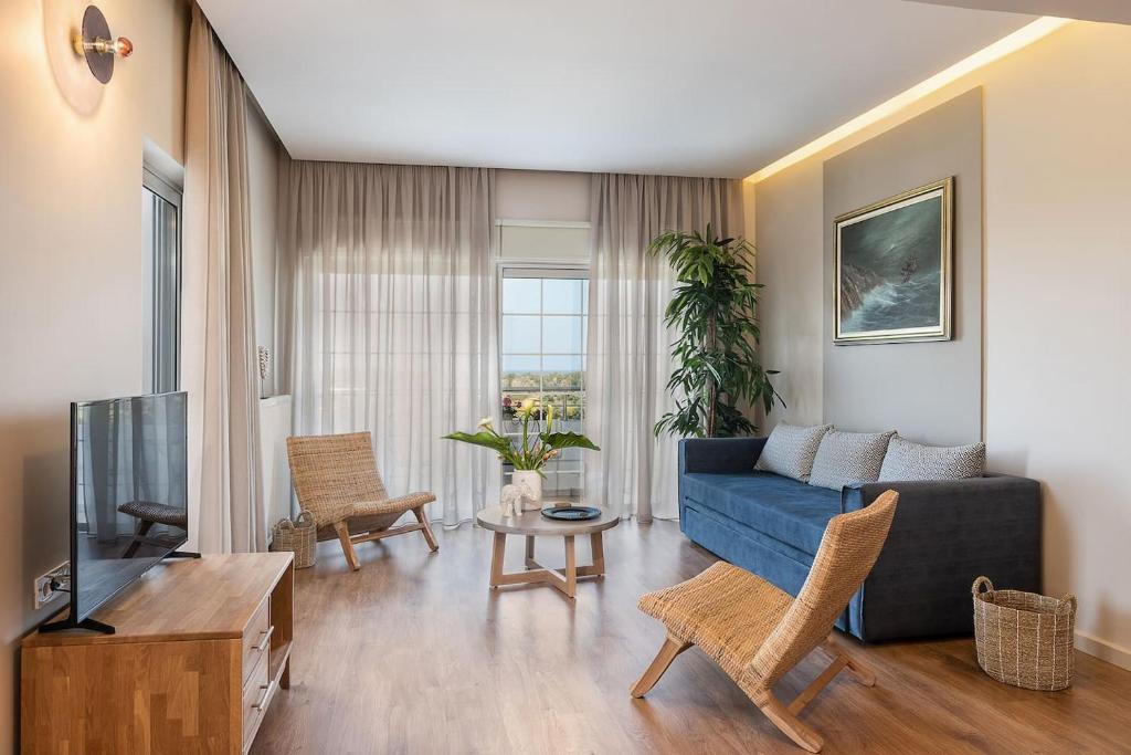 加藤-达拉特索Anemone Holiday Apartment的客厅配有蓝色的沙发和电视