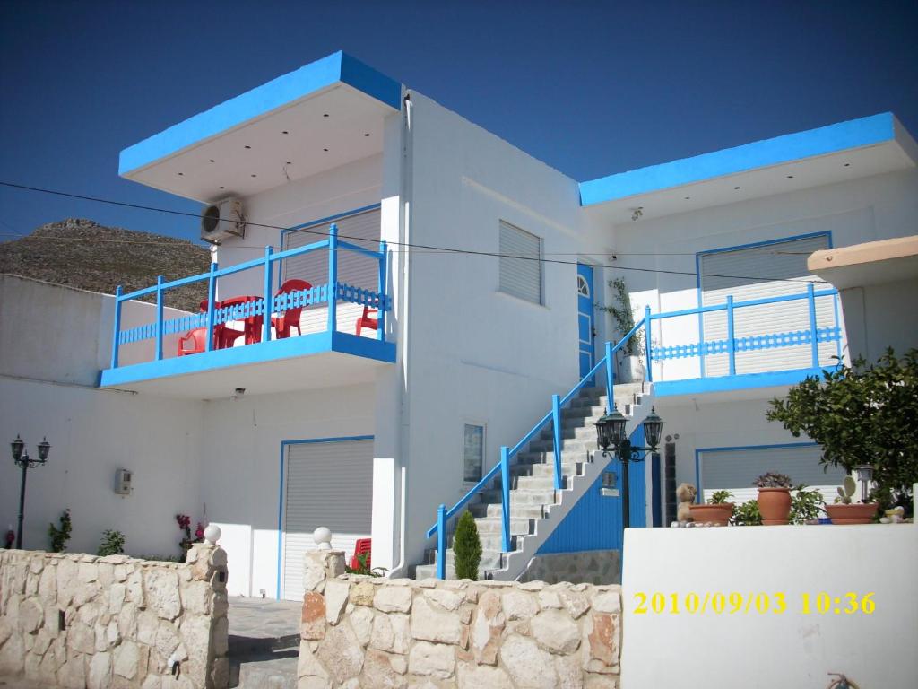 加藤扎克罗斯Galini的白色的房子,设有蓝色的阳台和楼梯