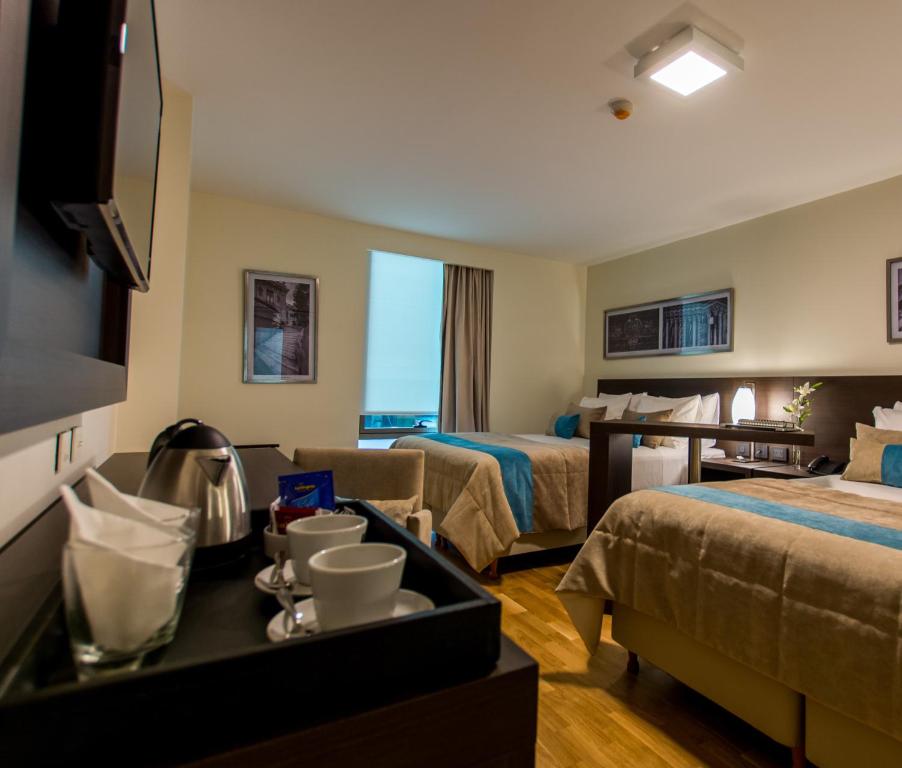 科尔多瓦Caseros 248 Hotel的一间酒店客房,设有两张床和电视