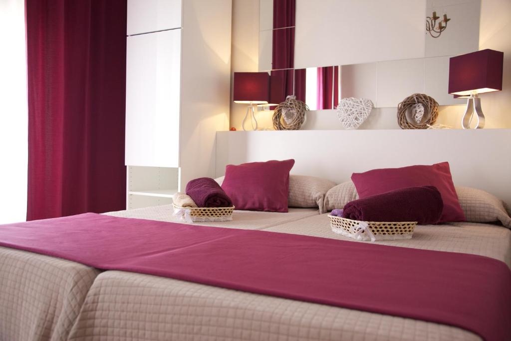 科尔多瓦奥地利广场公寓酒店的一间卧室配有一张带紫色床单的大床
