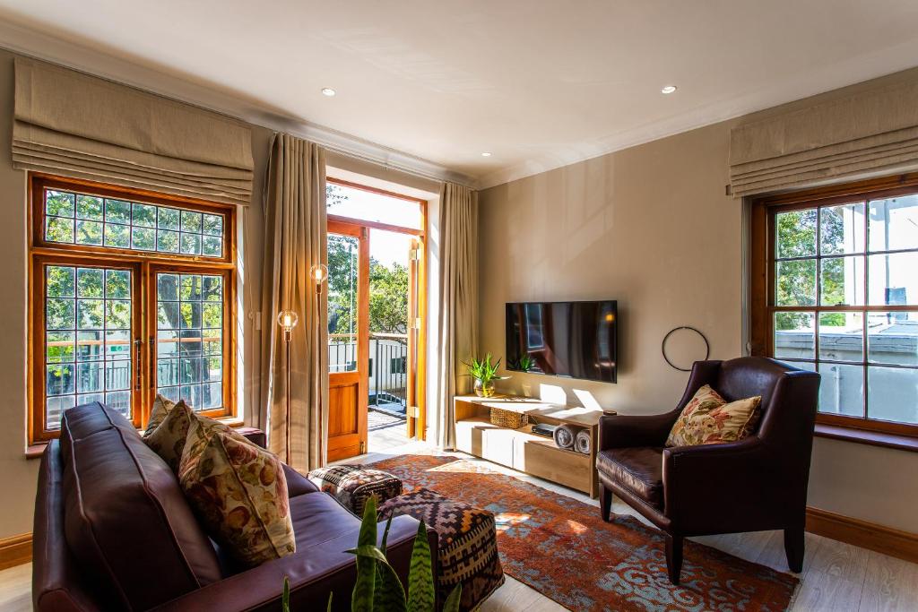 斯泰伦博斯Koetsiershuis的客厅配有沙发、椅子和电视