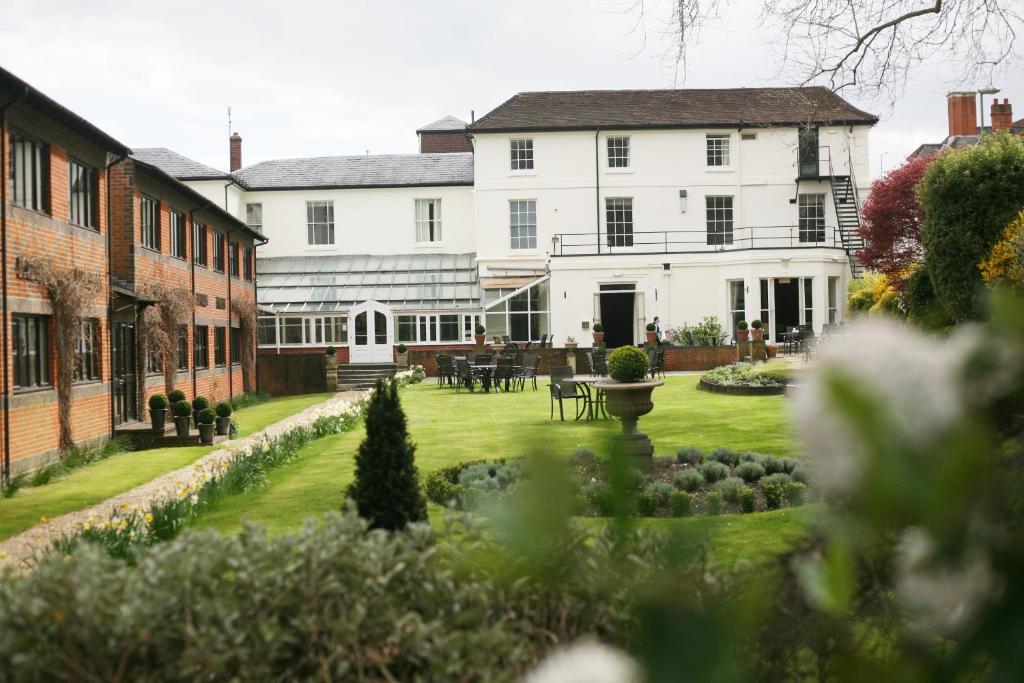温彻斯特Winchester Royal Hotel的一座白色的大房子,前面设有一个花园