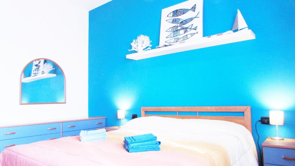 维莫德罗内Casa San Raffaele的蓝色的卧室,配有床和蓝色的墙壁