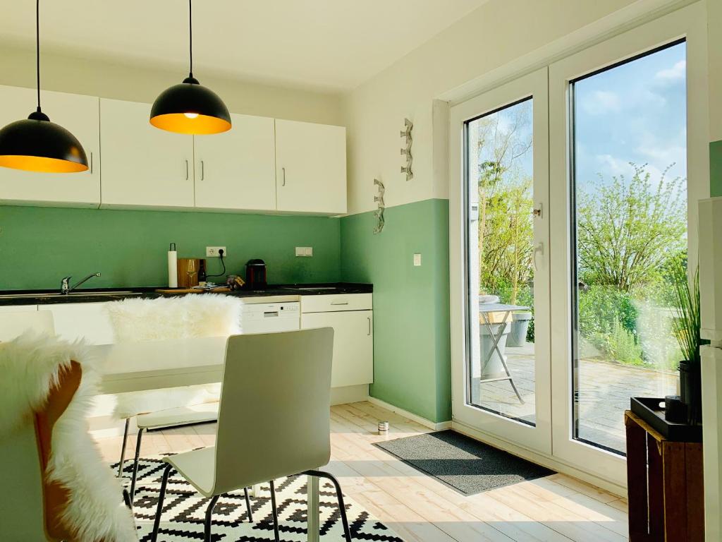 Bandorf欧贝维特度假屋的厨房设有绿色的墙壁和桌椅