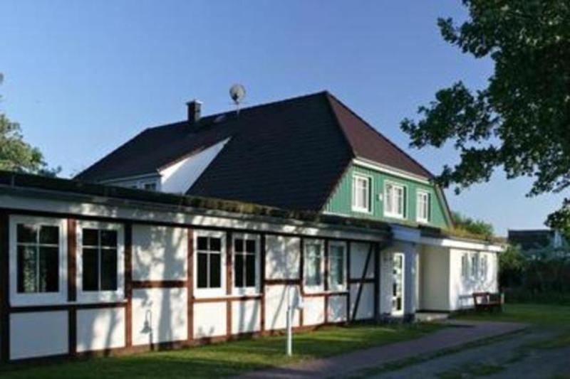 阿伦斯霍普Gaestehaus _ Strandhalle的白色绿色的黑屋顶房子