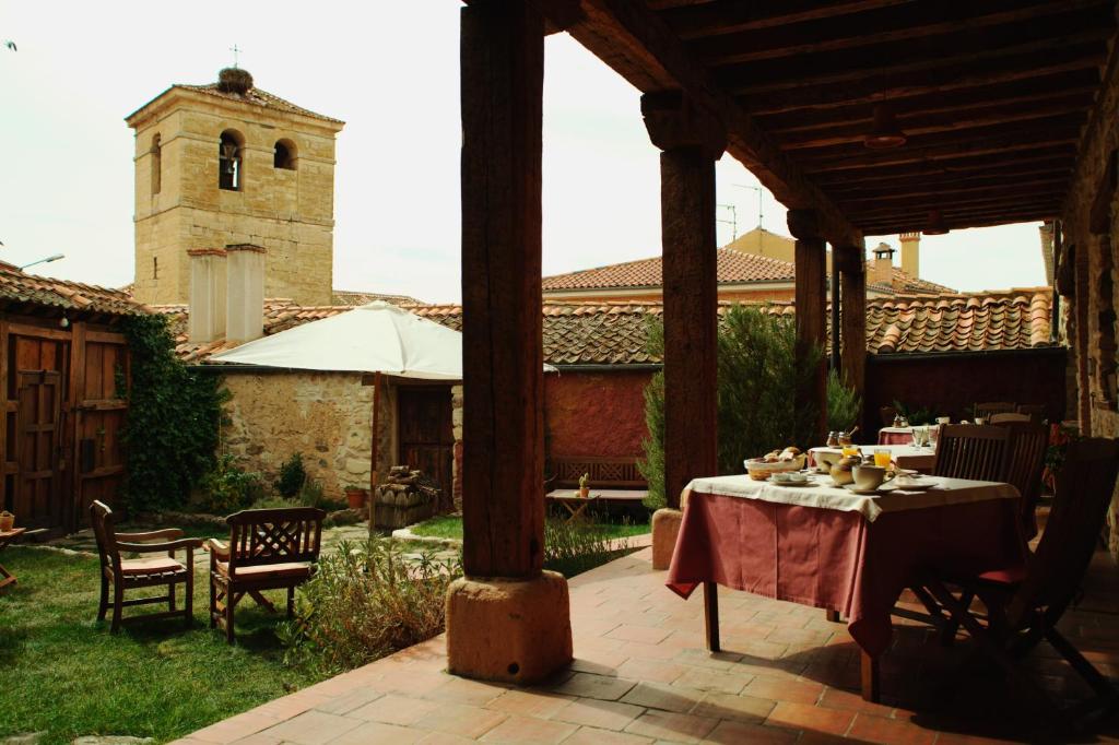 埃斯皮尔多卡索那艾斯博得酒店的一个带桌椅的庭院和一个教堂