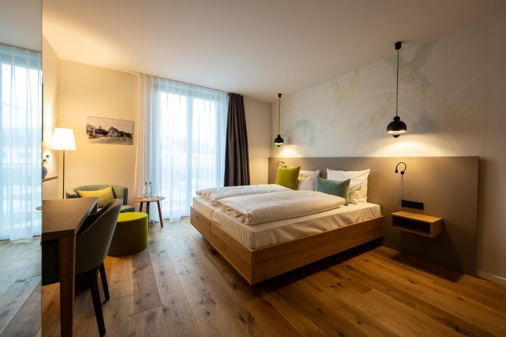 Eimeldingenzum LOEWEN的配有一张床和一张书桌的酒店客房