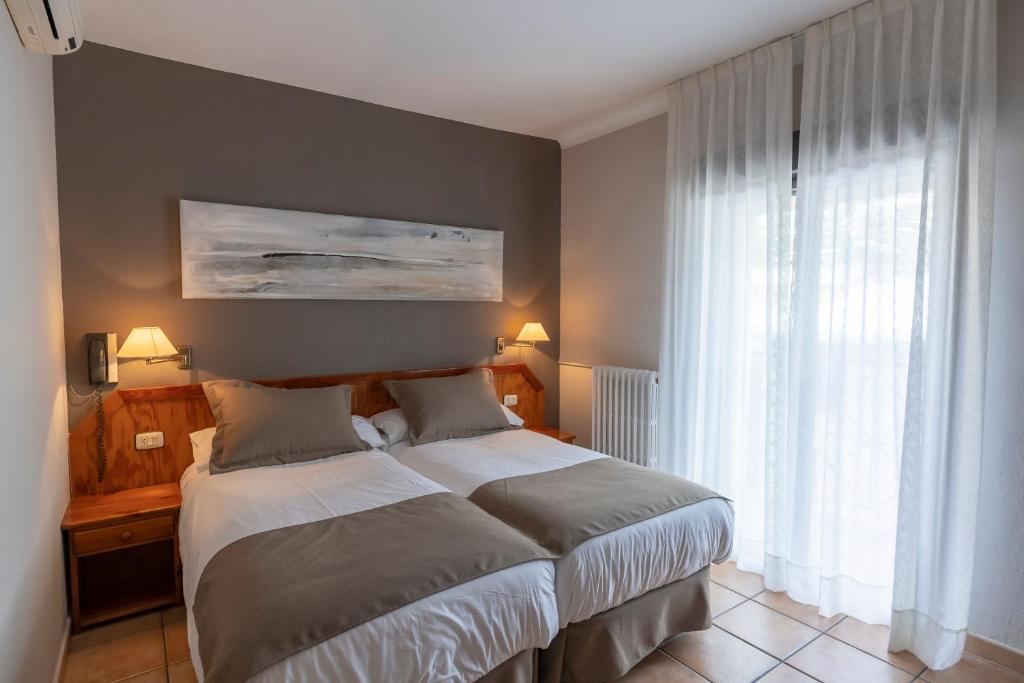 恩坎普巴黎酒店的一间卧室设有一张床和一个大窗户