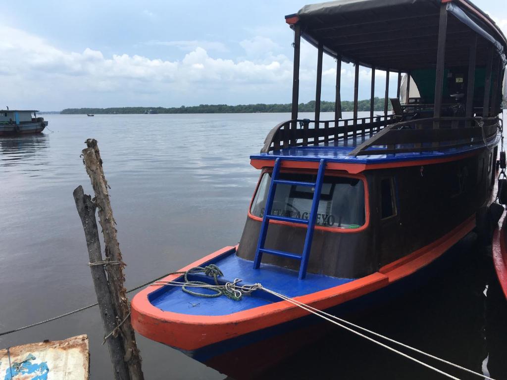 庞卡兰布翁Orangutan Houseboat Park Tanjung Puting的被绑在水面上的一个码头上的船
