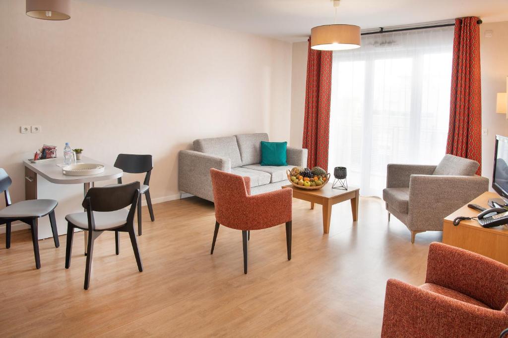 新城勒鲁瓦多米蒂斯莱沙布勒多洛公寓式酒店的客厅配有沙发和桌椅