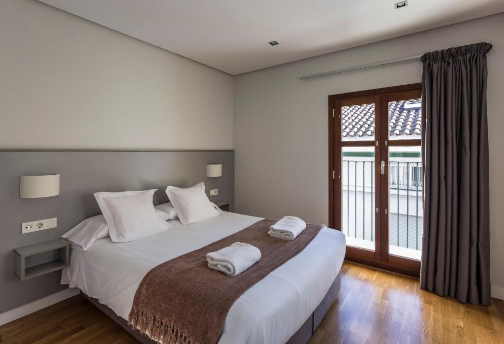 瓦伦西亚Mon Suites Catedral的一间卧室配有一张大床和两条毛巾