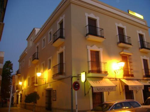 洛斯帕拉西奥西维利亚夫兰卡圣克鲁斯酒店的前面有停车位的建筑
