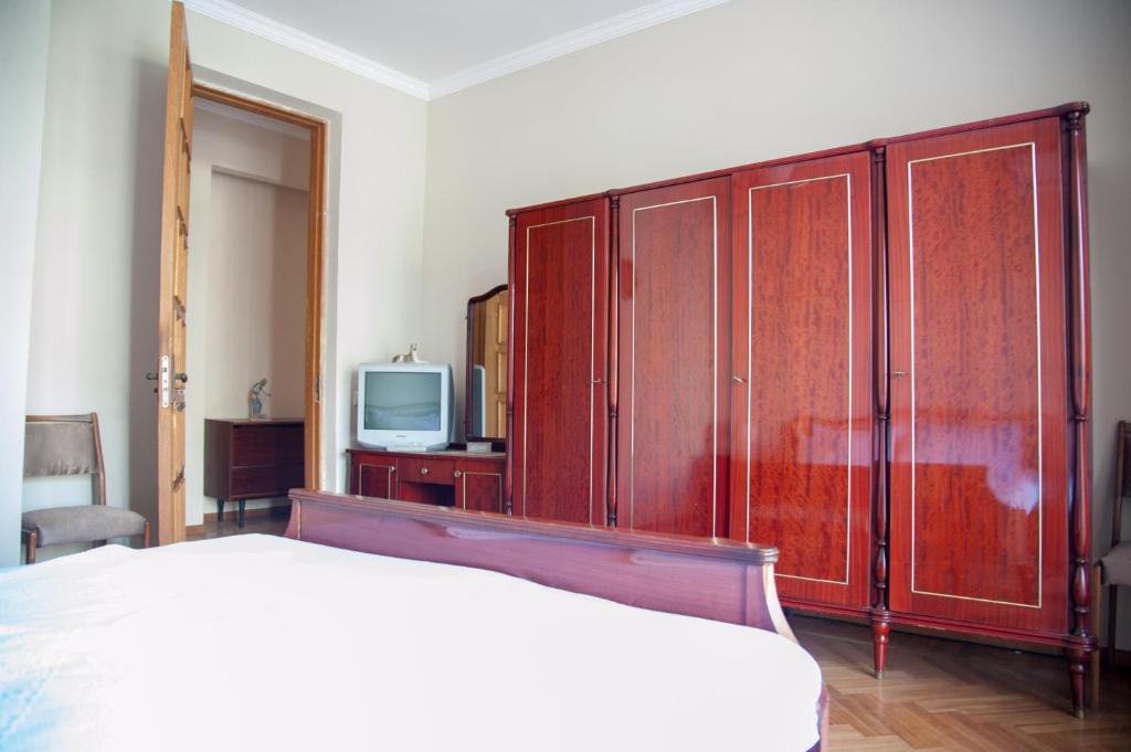 巴统Cozy Guest House in Old Batumi的一间卧室配有一张床和一台电视。