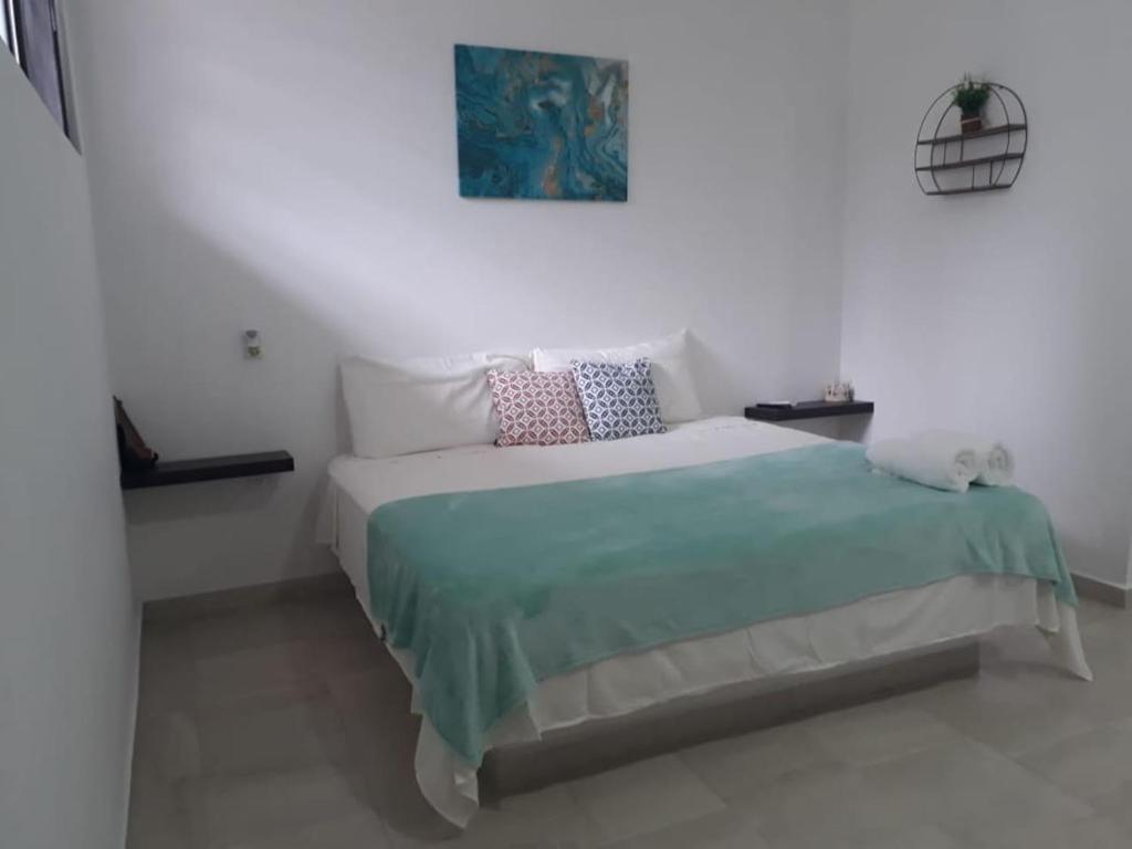 坎昆Estudio en Cancún centro的白色卧室配有一张带蓝色毯子的床