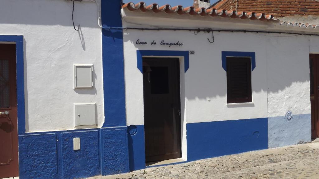 São Pedro do CorvalCasa do Compadre - Casas de Taipa的蓝白色的建筑,有门