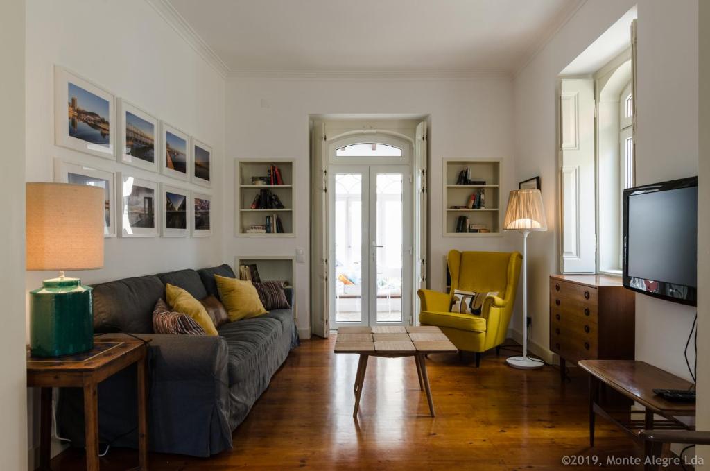 埃斯托利尔Casa do Tamariz, XIX century Beach House的带沙发和黄色椅子的客厅