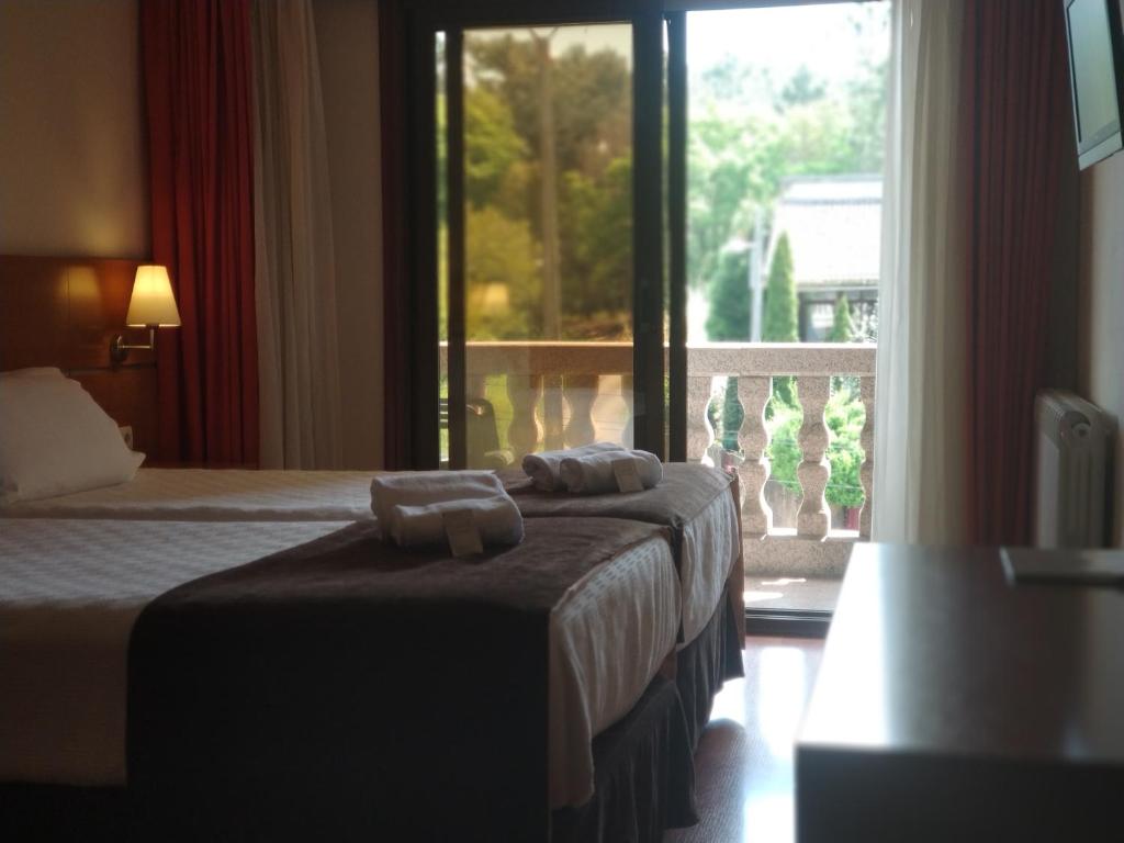 维戈Hotel Avión by Bossh Hotels的酒店客房设有两张床和大窗户。