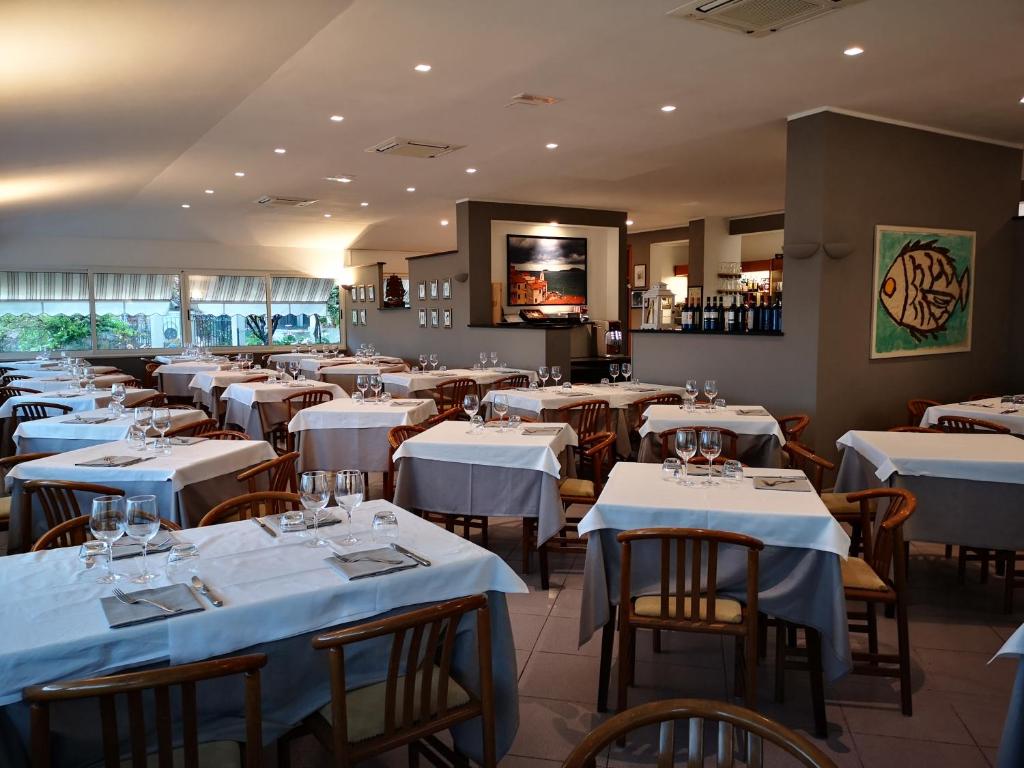 特拉罗Miramaretellaro的餐厅配有桌椅和白色的桌布