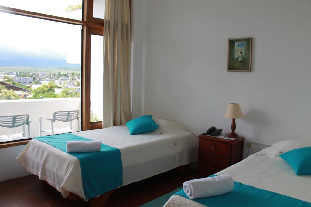 阿约拉港德尔马旅馆的酒店客房设有两张床和一个阳台。