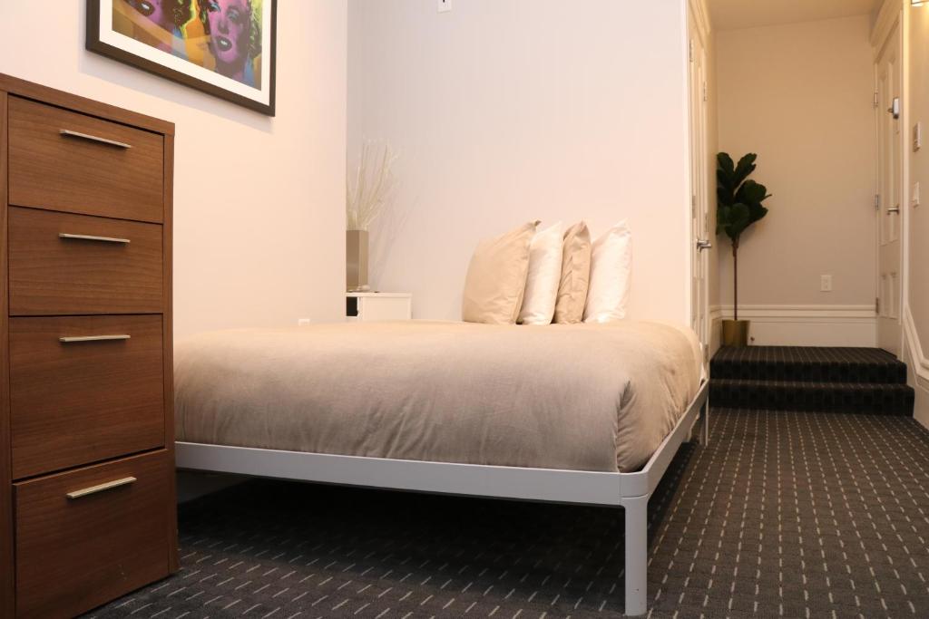 波士顿Charming & Stylish Studio on Beacon Hill #3的一间卧室配有带白色床单和枕头的床。
