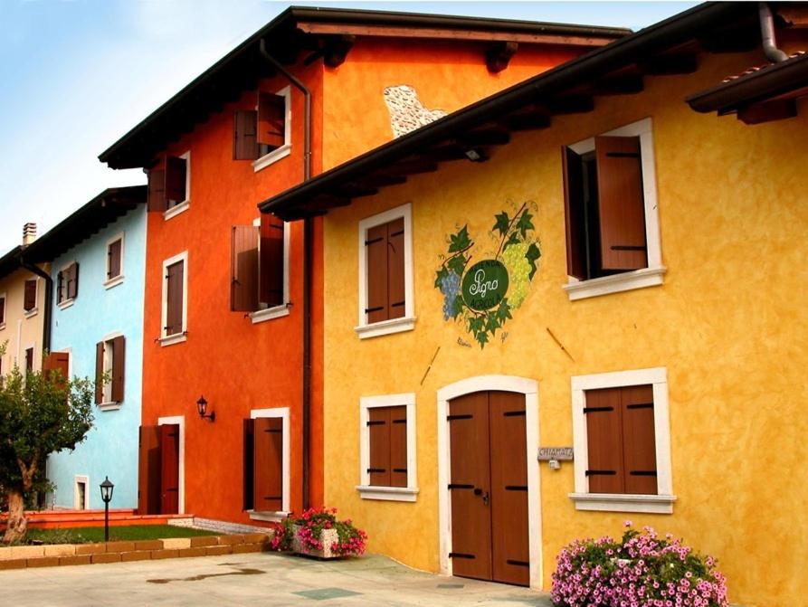 维罗纳自由镇皮格诺农庄农家乐的黄色和橙色的建筑,上面有标志