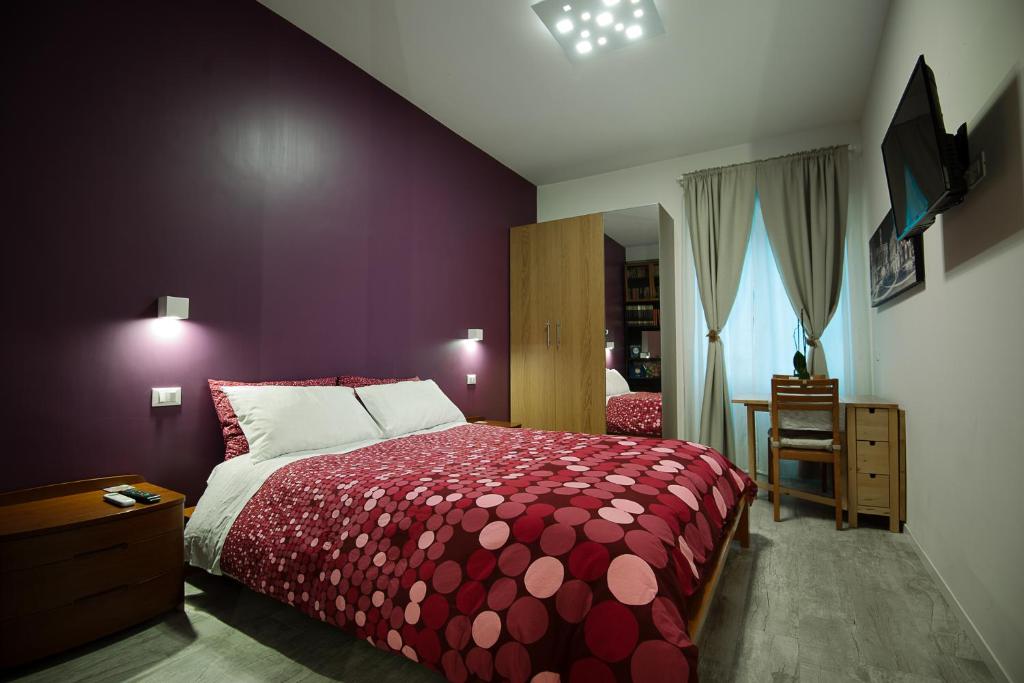 罗马德利兹伊法布里奇奥旅馆的一间卧室配有一张红色床罩的床