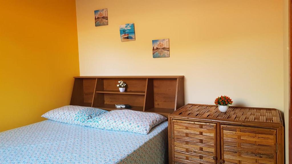 巴拉格兰德Pousada Barra Sol的一间卧室配有一张带木制床头板和一张桌子的床。