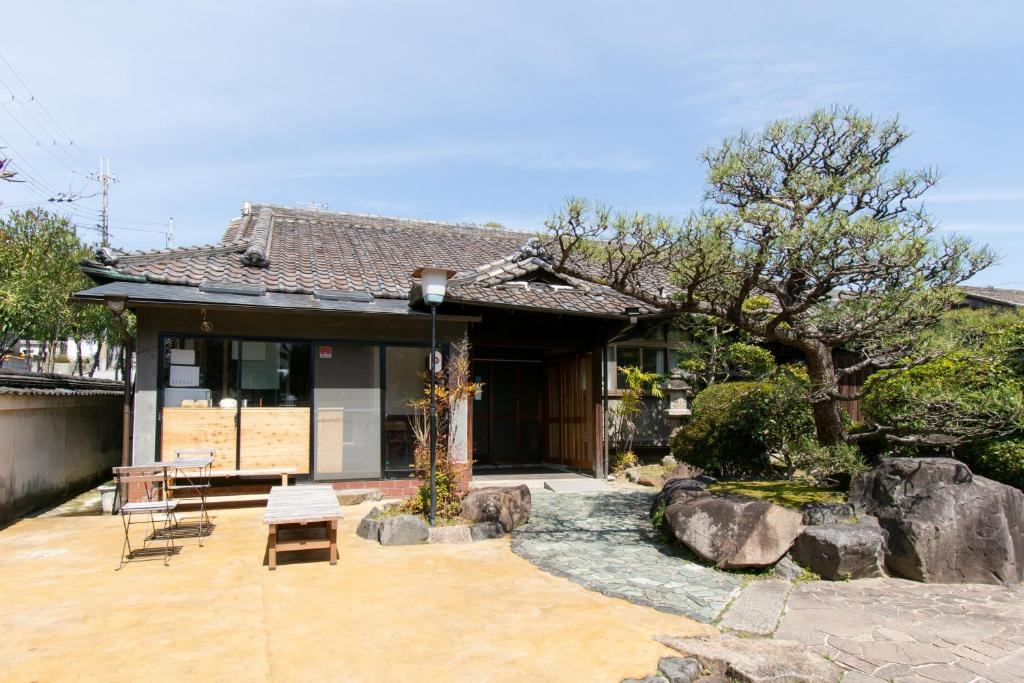 奈良Yuzan Guesthouse的一座带庭院的房子,前面有一棵树