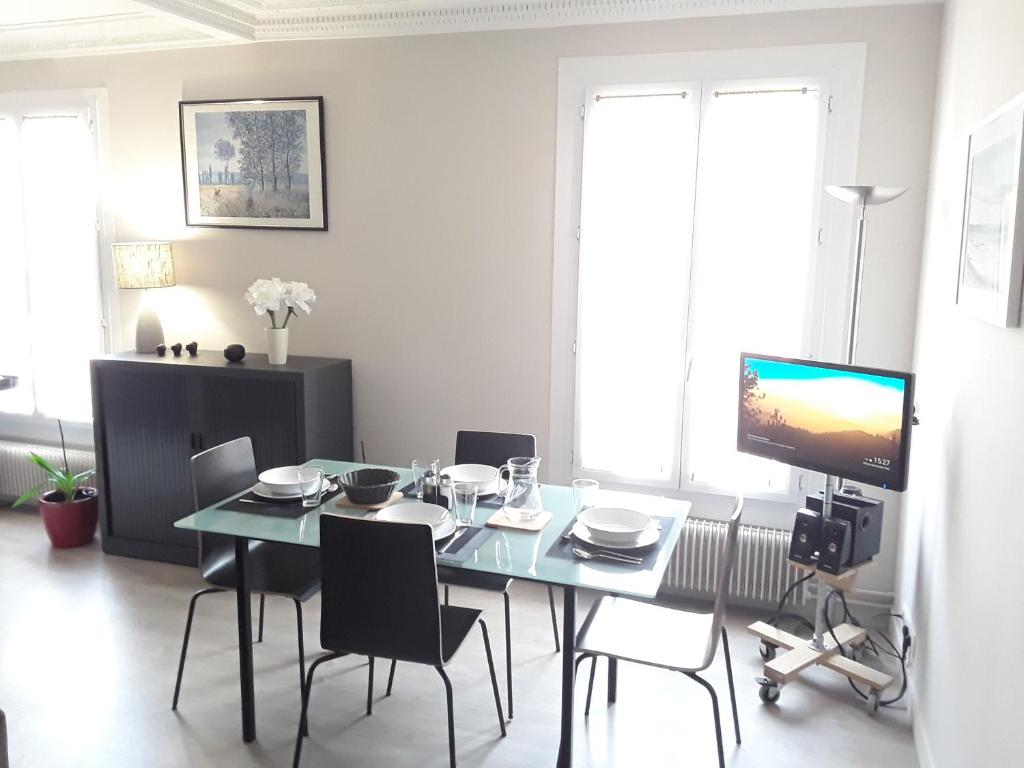 巴黎Apartment with Car Park - Bastille Neighborhood的一间带桌椅和电视的用餐室