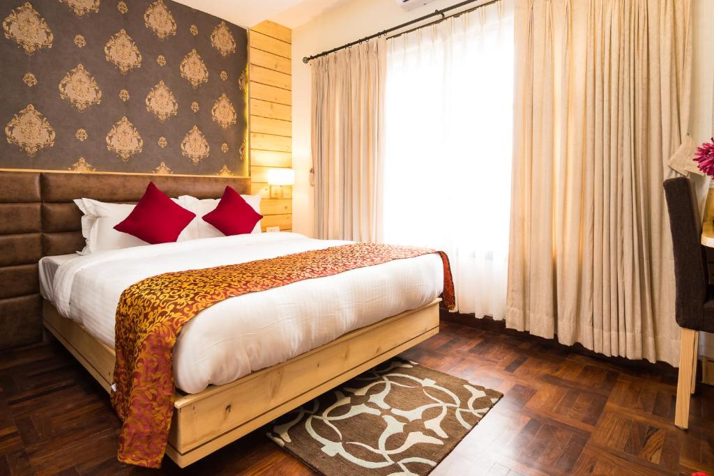 迦瓦拉科尔Fresco Retreat的一间卧室配有一张带红色枕头的床和一扇窗户