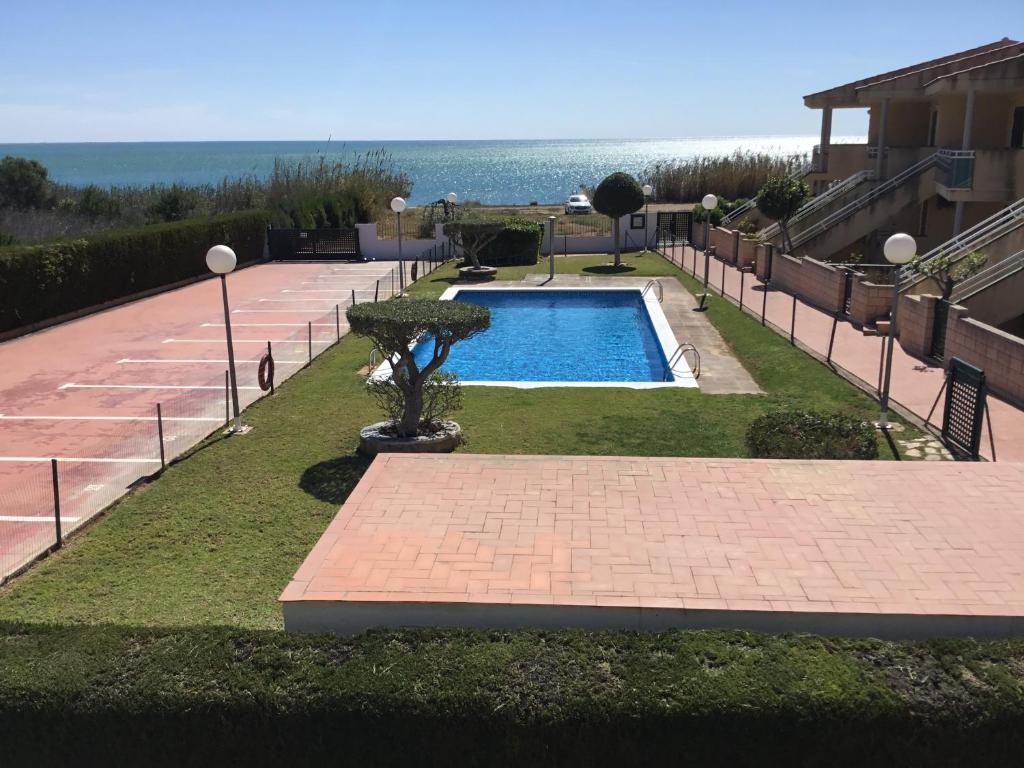 莱斯卡瑟斯-达尔卡纳Apartamento frente al mar的一座位于庭院内的游泳池,背景是大海