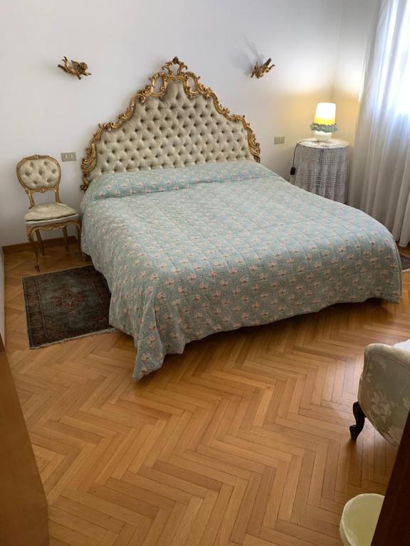 蒙扎卡米拉别墅的一间卧室配有一张床,铺有木地板