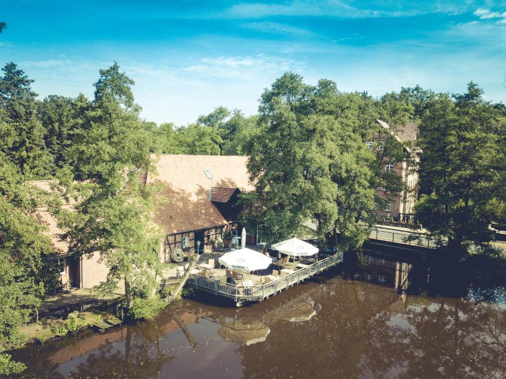 吕讷堡海利根塔尔瓦瑟穆赫酒店的河流上房屋的空中景观