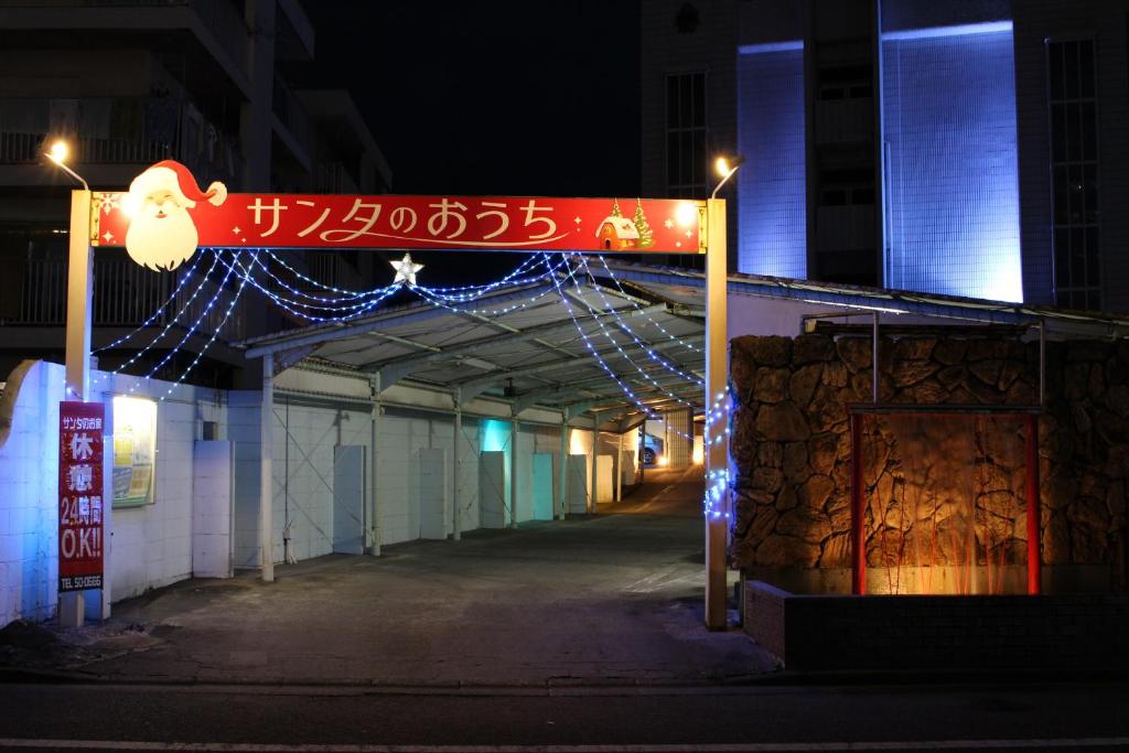 宫崎Santa no Ouchi-LoveHotel的建筑的标志,上面有圣诞灯
