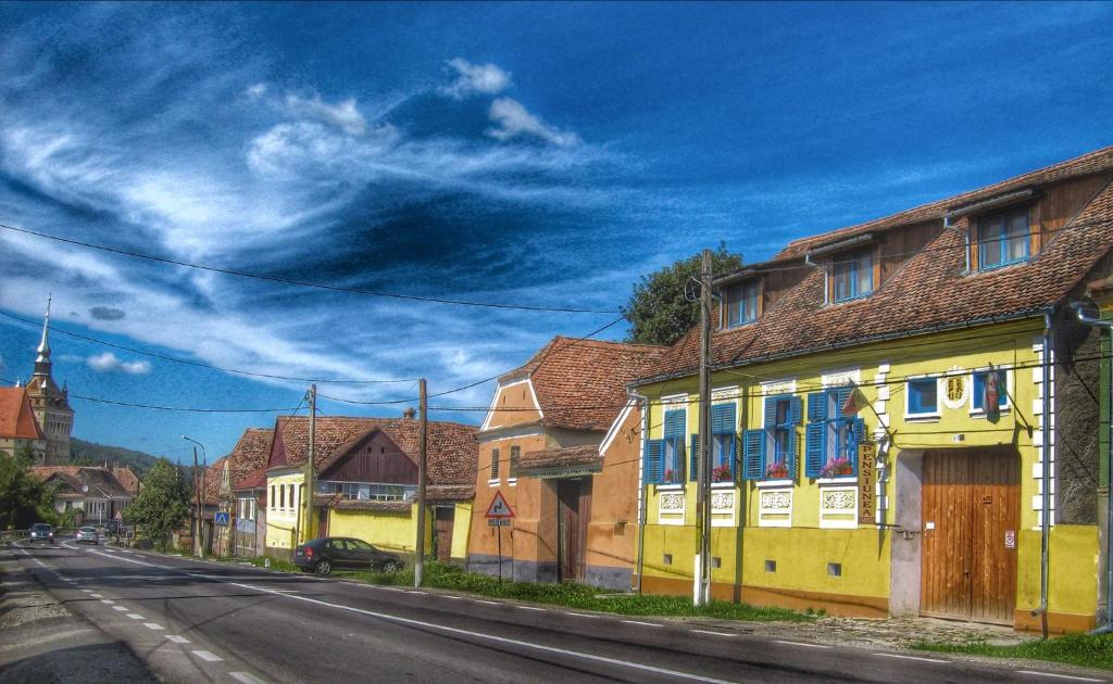 SaschizPension Cartref的路边有黄色房子的街道