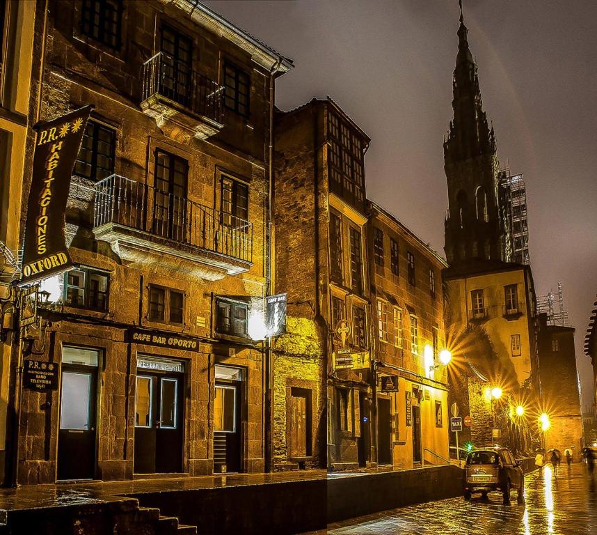 圣地亚哥－德孔波斯特拉Oxford Suites Santiago de Compostela的夜间与教堂的城市街道