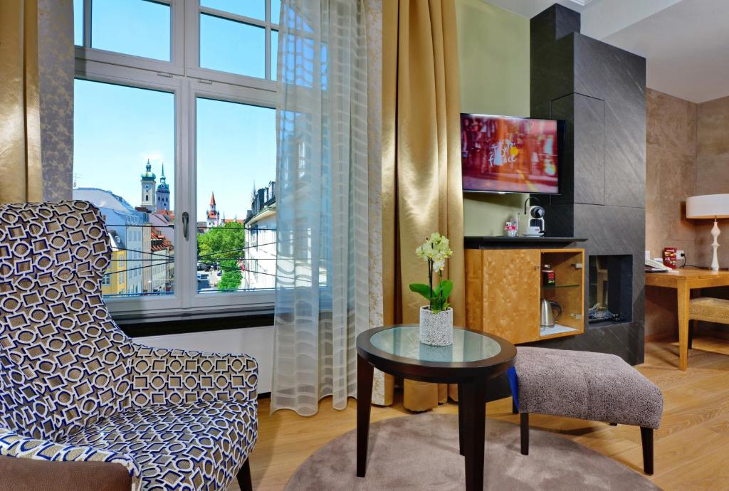 慕尼黑图芭拉乌酒店的客厅配有椅子、桌子和窗户