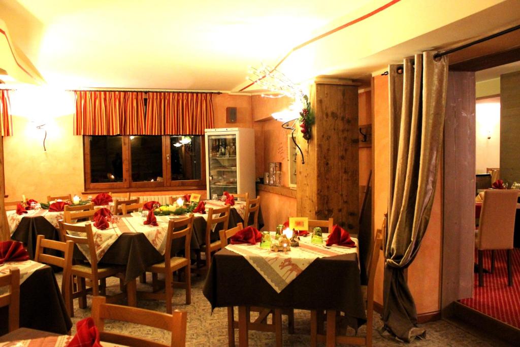 福波洛阿德勒尔酒店的一间设有桌椅和红色弓的餐厅