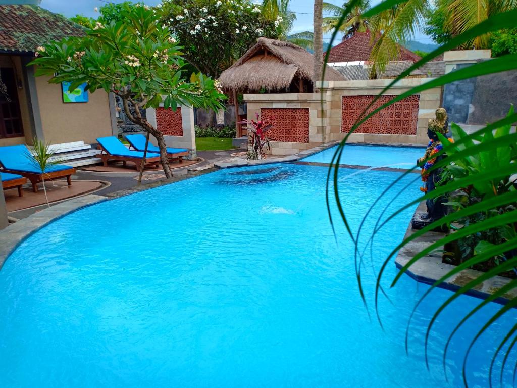 班尤温当曼简甘美景住宿加早餐旅馆的一座大型蓝色游泳池,位于房子旁边