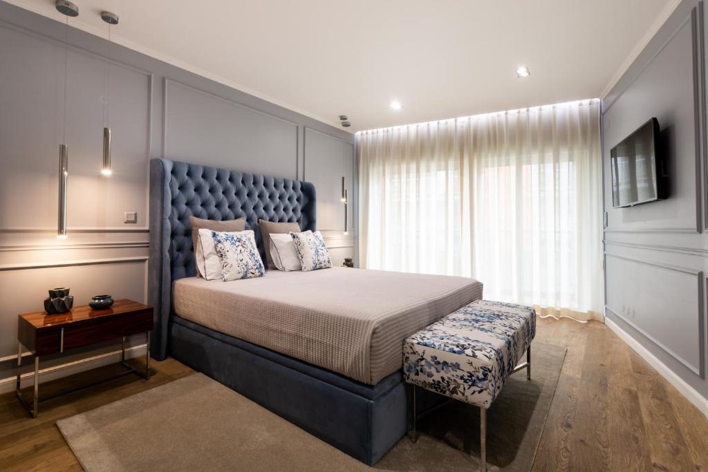 蓬塔德尔加达Azor Central Lodge的一间卧室配有一张大床和蓝色床头板