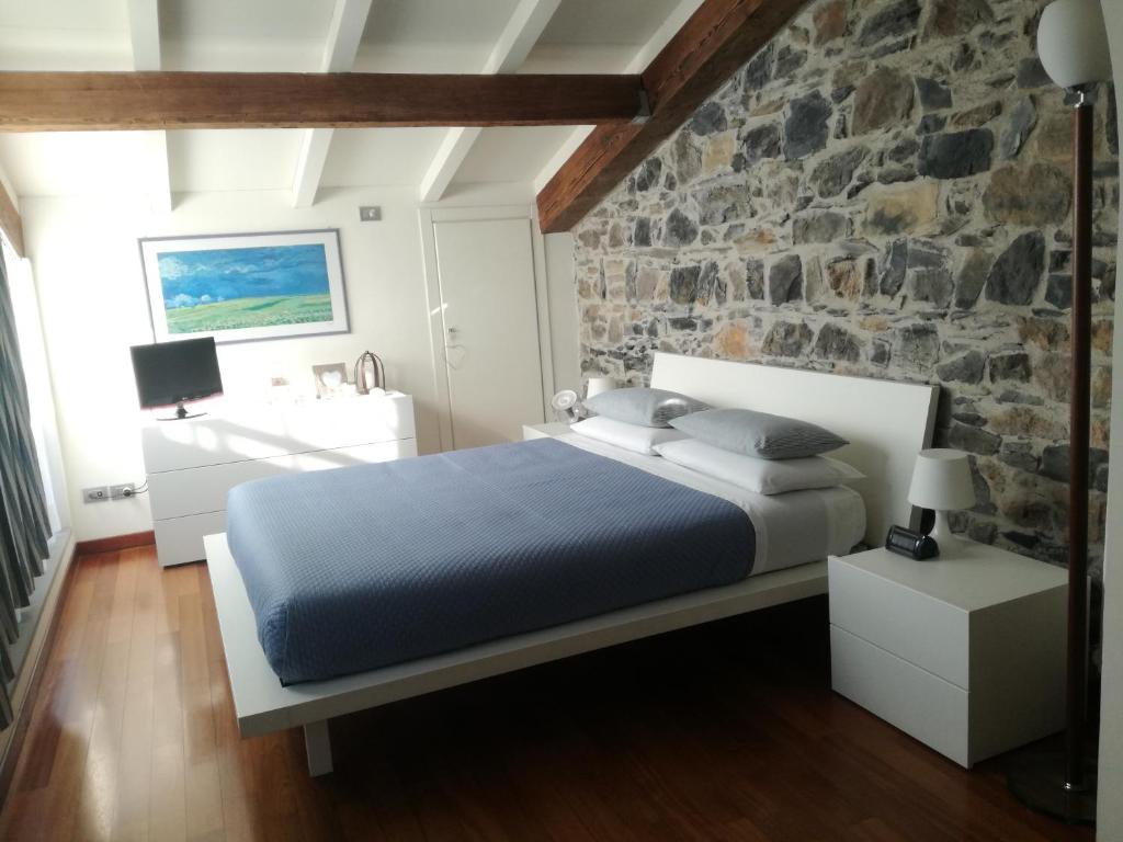斯培西亚La Pietra del Golfo的一间卧室设有一张床和石墙