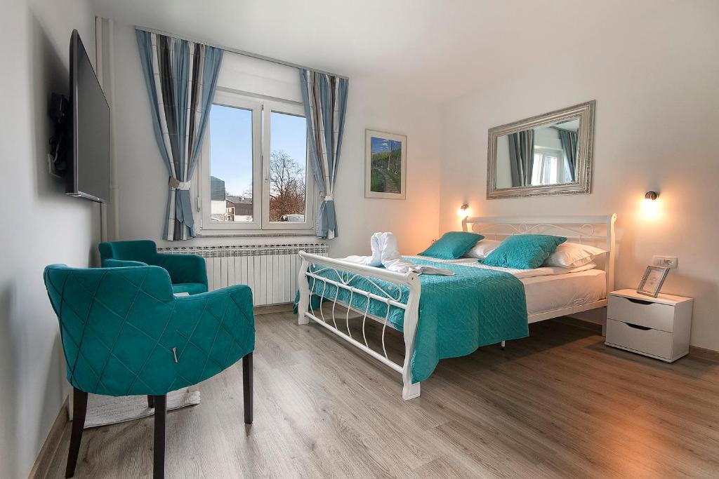 普利特维采湖Emerald Luxury Apartments的一间卧室配有一张床和一把椅子