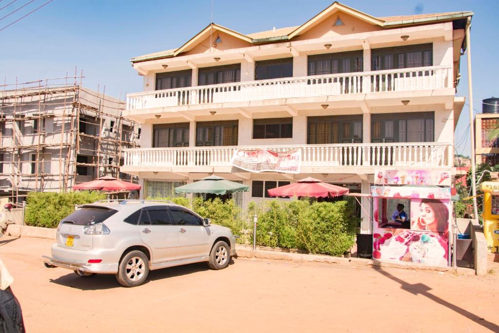 坎帕拉Florida Hotel Zaana Kampala的停在大楼前的白色汽车