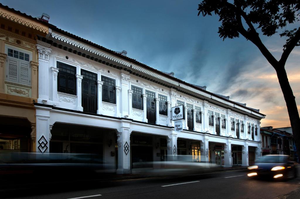 新加坡Venue Hotel的街上的一座建筑物,汽车驶过