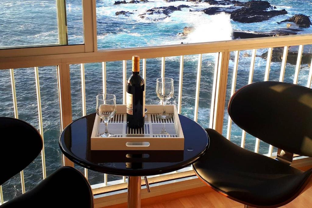 马德拉港Ocean Skyline Mesa del Mar Tenerife的阳台上的桌子上摆放着一瓶葡萄酒和玻璃杯