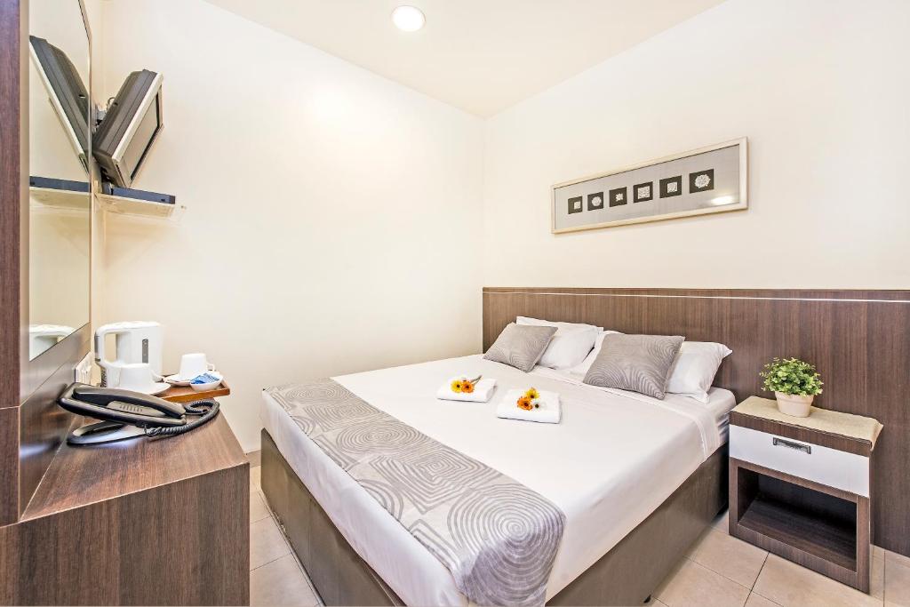 新加坡Hotel 81 Balestier的一间卧室,配有一张带两盘食物的床